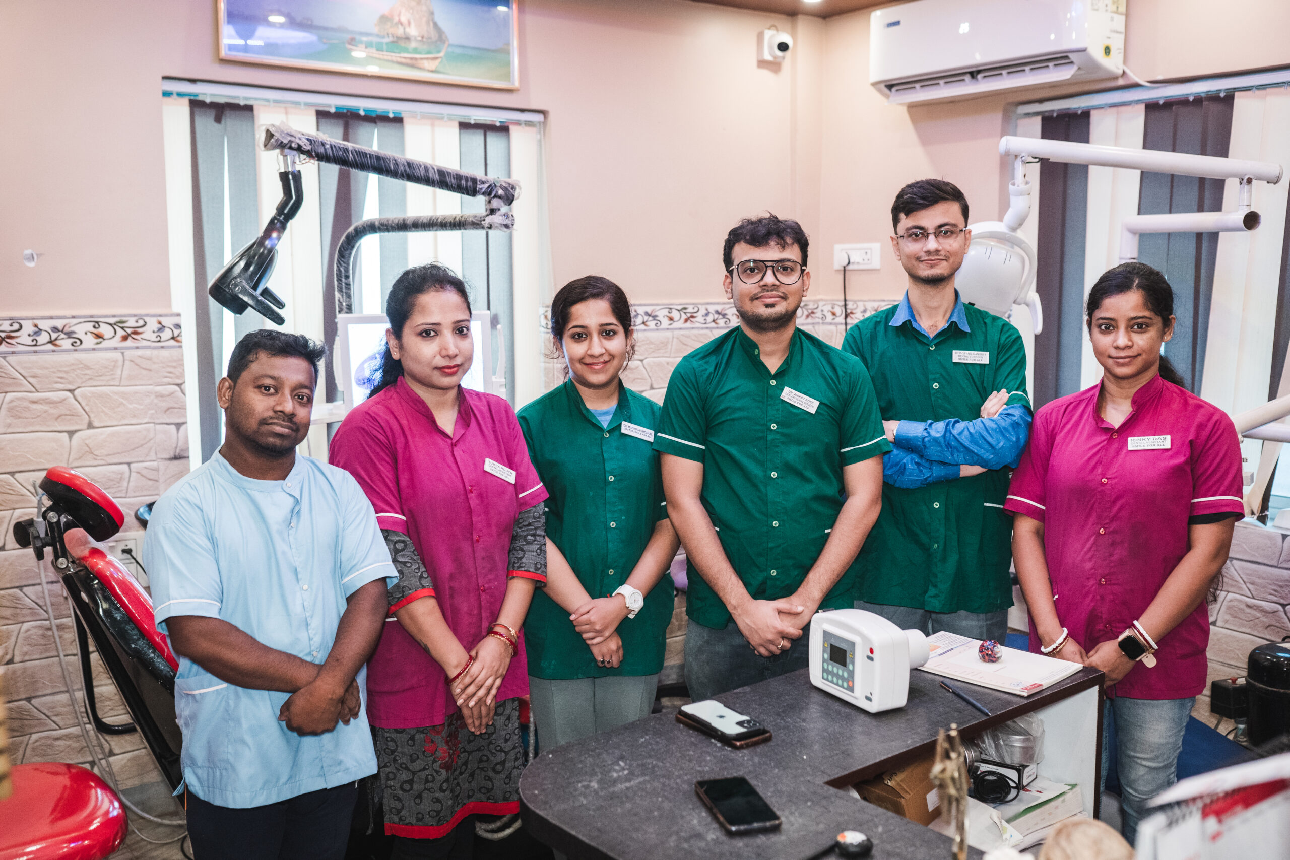 Professional dental clinic staff smiling in their modern commercial office reception area.